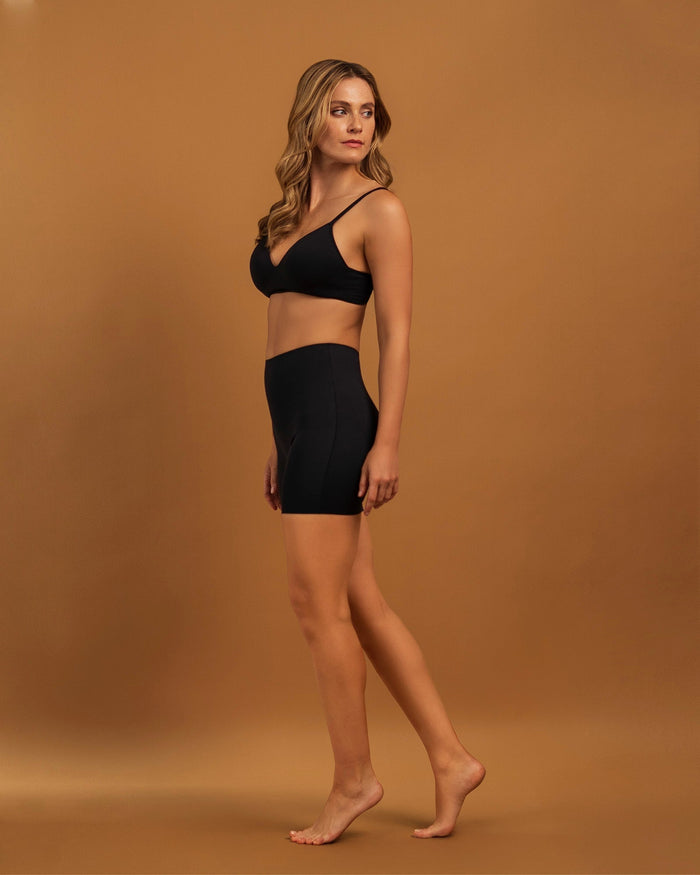 Woman wearing the High-Waisted Seamless Shaping Shorts in Black, full-length side view