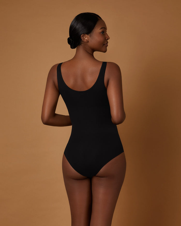 Woman wearing the Seamless Shaping Bodysuit in Black, back view
